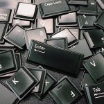 A black and white photo of a jumbled pile of keyboard keys